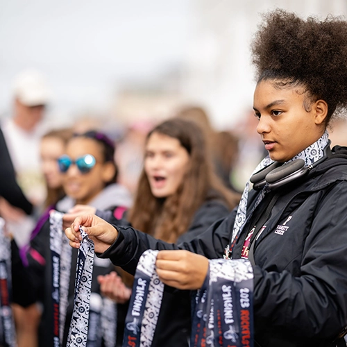 volunteer handing medals out